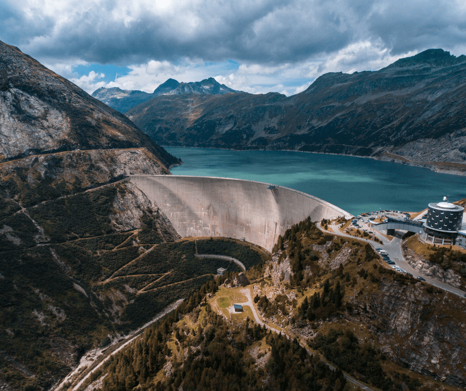 A water dam and its reservoir on a bright, cloudy day.