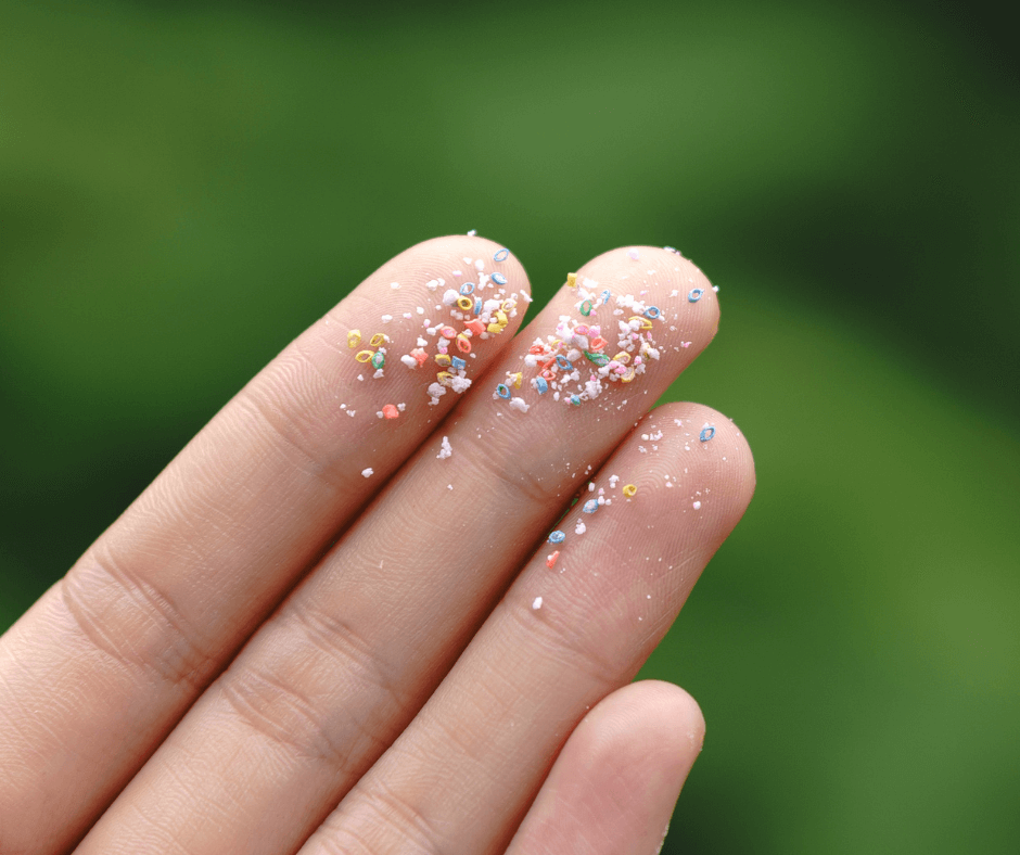 A close-up of some microplastics on someone’s fingertips.